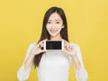 Smiling casual young woman holding smartphone and showing the blank screen Royalty Free Stock Photo