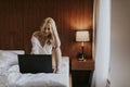 Smiling casual young woman using laptop in bed at home Royalty Free Stock Photo