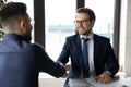 Smiling Caucasian businessman handshake male colleague at briefing Royalty Free Stock Photo