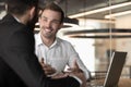 Smiling Caucasian businessman talk cooperating with male colleague