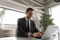 Smiling Caucasian businessman working on laptop in office Royalty Free Stock Photo