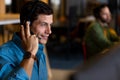 Smiling caucasian casual businessman using phone headset and using computer in casual office Royalty Free Stock Photo