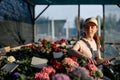 smiling caucasian female gardene writing in notebook in greenhouse, sit next to flowers Royalty Free Stock Photo