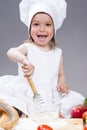 Smiling Caucasian Girl In Cook Uniform Making a Mix of Flour, Eggs and Vegetables With Whisk Royalty Free Stock Photo