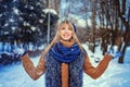 Smiling Caucasian girl throwing snow in the air at sunny winter day. Emotional young happy woman wearing casual having Royalty Free Stock Photo