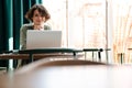 Smiling caucasian girl working with laptop while sitting in cafe Royalty Free Stock Photo