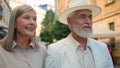 Smiling Caucasian happy family old couple elegant man gentleman woman lady pensioners tourists walk city street cafe Royalty Free Stock Photo