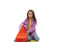 Smiling Caucasian kid schoolgirl 5-6 year old, with orange backpack sitting isolated on white background. Back to school Royalty Free Stock Photo