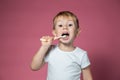 Smiling caucasian little boy cleaning his teeth with manual children toothbrush