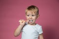 Smiling caucasian little boy cleaning his teeth with manual children toothbrush