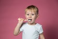 Smiling caucasian little boy cleaning his teeth with manual children toothbrush