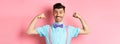 Smiling caucasian man with bow-tie and suspenders, showing muscles and feeling strong, flexing biceps to show-off Royalty Free Stock Photo