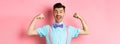 Smiling caucasian man with bow-tie and suspenders, showing muscles and feeling strong, flexing biceps to show-off Royalty Free Stock Photo