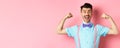 Smiling caucasian man with bow-tie and suspenders, showing muscles and feeling strong, flexing biceps to show-off Royalty Free Stock Photo