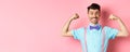 Smiling caucasian man with bow-tie and suspenders, showing muscles and feeling strong, flexing biceps to show-off Royalty Free Stock Photo