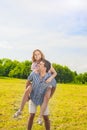 Smiling Caucasian Man Giving Woman Piggyback Ride Outdoors. Youth Lifestyle, Happiness, Love, dating, Romance , Vacation Concept. Royalty Free Stock Photo