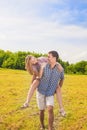 Smiling Caucasian Man Giving Woman Piggyback Ride Outdoors. Youth Lifestyle, Happiness, Love, dating, Romance , Vacation Concept. Royalty Free Stock Photo