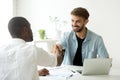 Smiling caucasian manager and african client shake hands making Royalty Free Stock Photo