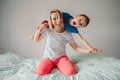 Smiling Caucasian mother and boy son playing in bedroom at home. Child sitting on moms shoulders and laughing. Family having fun Royalty Free Stock Photo