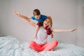 Smiling Caucasian mother and boy son playing in bedroom at home. Child sitting on moms shoulders and laughing. Family having fun Royalty Free Stock Photo