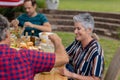 Smiling caucasian senior woman sitting with family eating meal together in garden Royalty Free Stock Photo