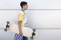 Smiling caucasian teenage boy with skateboard in hand. He is  on a wall. Urban lifestyle Royalty Free Stock Photo