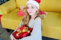 Smiling Caucasian Teenage lovely girl wearing red hat of Santa Claus and holding a big red gift box in Christmas and birthday Royalty Free Stock Photo