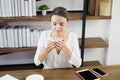 Smiling Caucasian woman happy with smell the aroma of hot coffee in the morning at cafe. She is relaxing with social online on Royalty Free Stock Photo