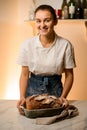 smiling caucasian woman holding fresh bread from the oven Royalty Free Stock Photo