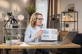 Smiling caucasian woman showing graphs and charts on laptop computer during video conference Royalty Free Stock Photo