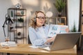 Smiling caucasian woman showing graphs and charts on laptop computer during video conference Royalty Free Stock Photo