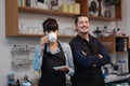 Smiling Caucasian Young barista couple love or partnership is wearing apron and drinking coffee relax in the coffee shop. Start up Royalty Free Stock Photo