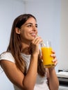 Smiling caucasian young woman drinking orange juice. Healthy life, domestic life Royalty Free Stock Photo