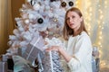 Smiling caucasian young woman opens box with christmas present. Christmas Royalty Free Stock Photo