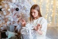 Smiling caucasian young woman opens box with christmas present. Christmas Royalty Free Stock Photo