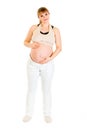 Smiling charming pregnant woman holding her belly