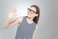 Smiling charming teenage girl in glasses showing her palm