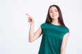 Smiling charming young woman in green top pointing away