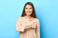 Smiling charming young woman showing thumb up isolated blue background . Royalty Free Stock Photo