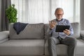 Smiling cheerful happy senior man waving and gesturing to camera having online video call on hand held tablet portable device Royalty Free Stock Photo