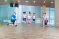 Smiling cheerful kids in school age playing together with jumping rope in gym. Children at physical education lesson in Royalty Free Stock Photo