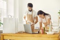 Smiling cheerful man and woman food delivery service workers packing online healthy meals orders