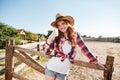 Smiling cheerful redhead cowgirl in hat showing thumbs up gesture Royalty Free Stock Photo