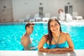 Smiling cheerful woman swimming in a clear pool on a sunny day.Having fun on vacation pool party.Friendly female enjoying relaxing Royalty Free Stock Photo