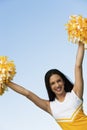 Smiling Cheerleader rising pom-poms Royalty Free Stock Photo