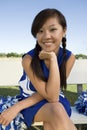 Smiling Cheerleader sitting on bench Royalty Free Stock Photo