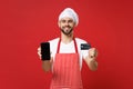 Smiling chef cook or baker man in striped apron t-shirt toque chefs hat isolated on red background. Cooking food concept Royalty Free Stock Photo