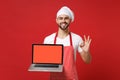 Smiling chef cook baker man in striped apron t-shirt toque chefs hat isolated on red background. Cooking food concept Royalty Free Stock Photo