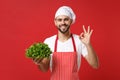Smiling chef cook or baker man in striped apron white t-shirt toque chefs hat isolated on red background. Cooking food Royalty Free Stock Photo