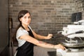 Smiling chef pressing dough making machine in kitchen